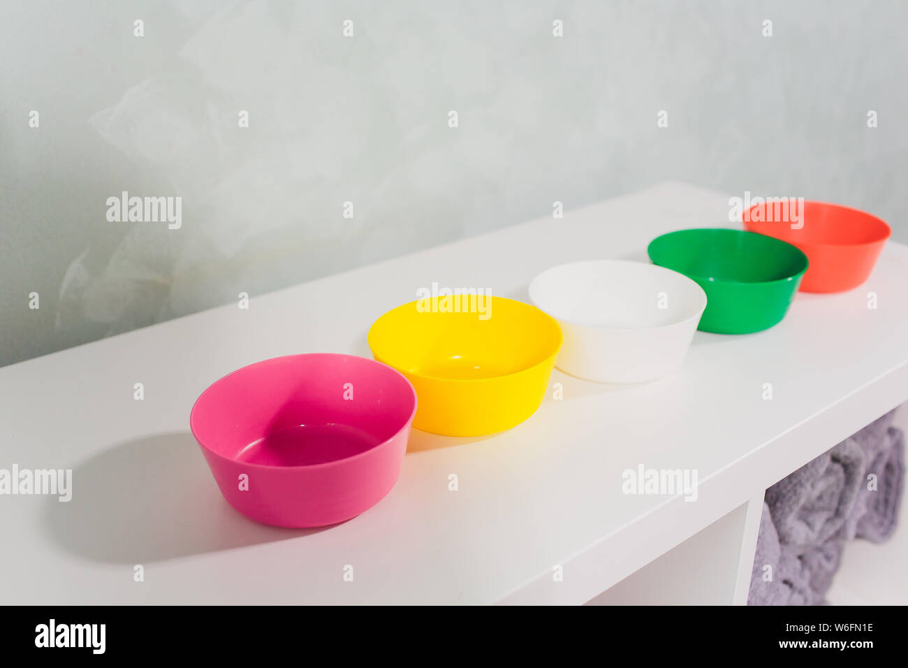 reusable colored plastic dishes on the shelf in the store Stock Photo