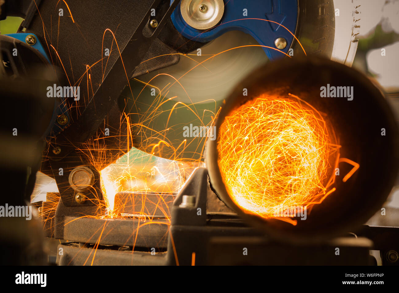 Closeup of Electric Grinder Cutting metal pipe with Bright Sparks