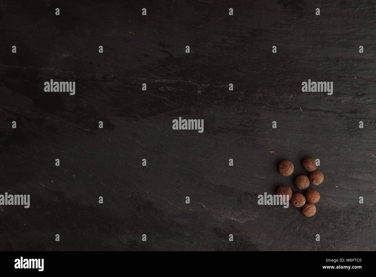 Jamaican peppercorns on slate background Stock Photo Alamy