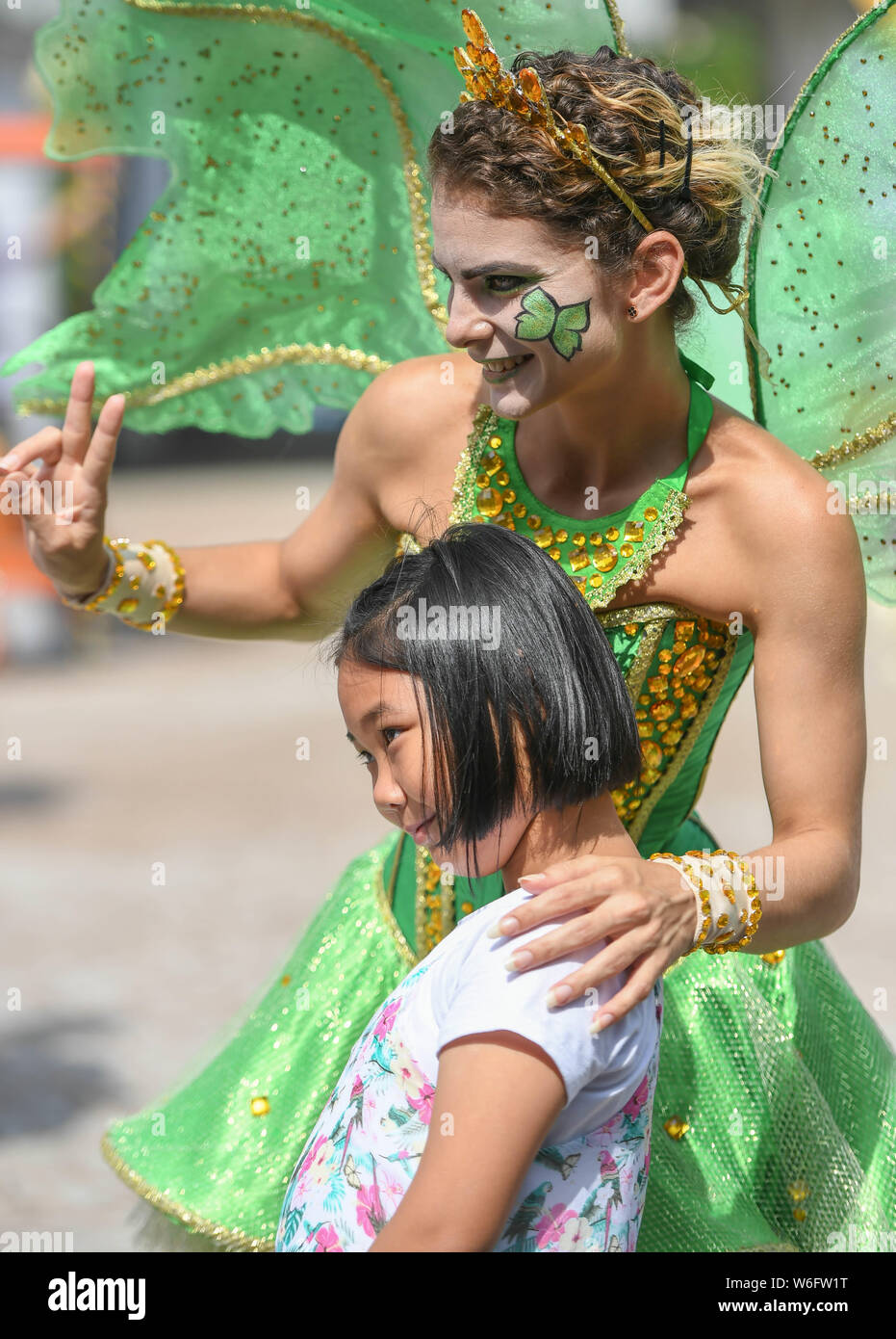 (190801) -- CHANGCHUN, Aug. 1, 2019 (Xinhua) -- Lazara Maria Gonzalezgil poses for photos with a tourist at the movie themed amusement park she works for in Changchun, northeast China's Jilin Province, Aug. 1, 2019. Lazara Maria Gonzalezgil is a 25-year-old Cuban dancer born in Villa Clara. Seeking to go further in her career and for a better future, Lazara came to China in 2017 and soon got signed by a Chinese culture and education company. In the past two years, she has traveled as a dancer to many cities across China, including Harbin, Beijing, Jinan, Shanghai, Guangzhou and Haikou. Nowaday Stock Photo