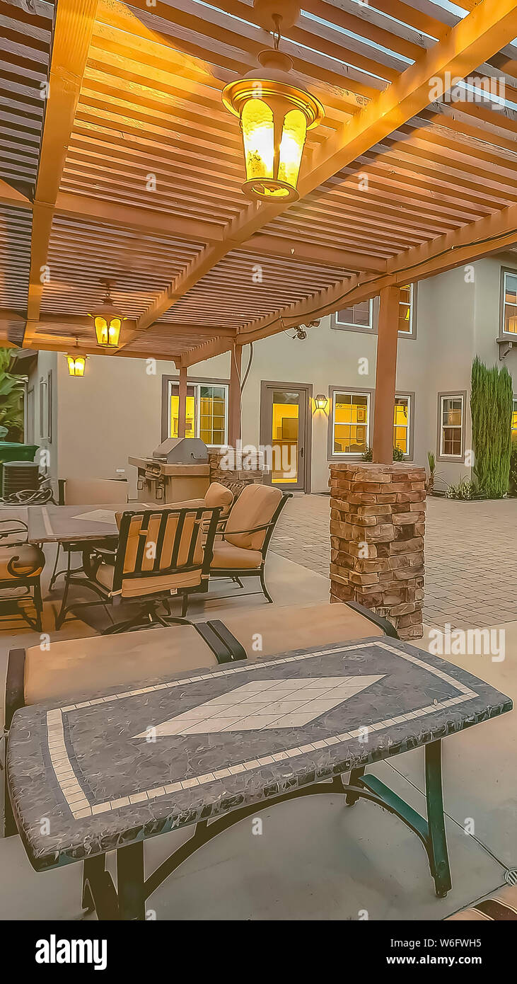 Vertical Outdoor Dining Area Under A Wooden Pergola On The