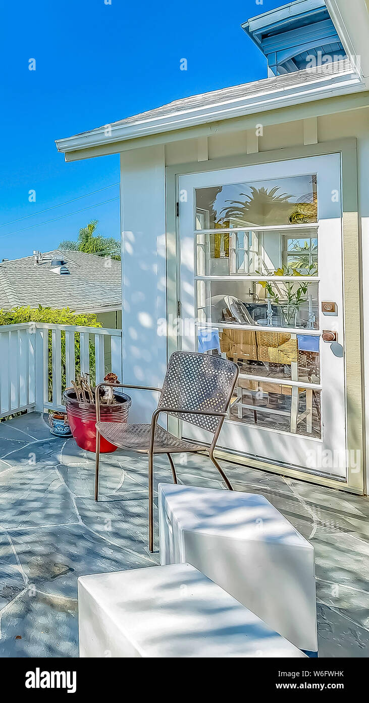 Vertical Chairs and barbecue grill at the balcony of a home with white