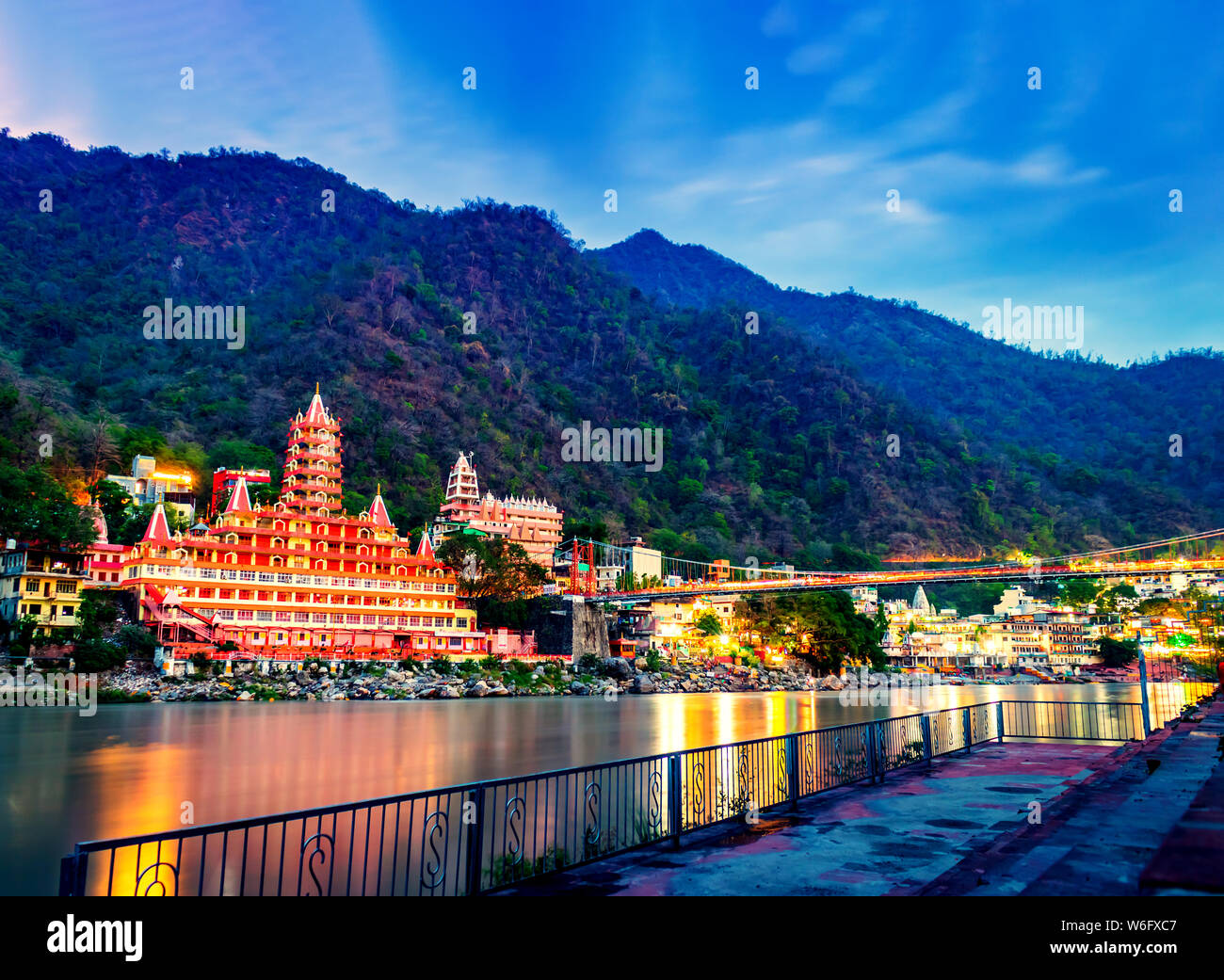 River Ganges, the famous bridge Laxman Jhula surrounded by temples and mountains around in Rishikesh, India Stock Photo