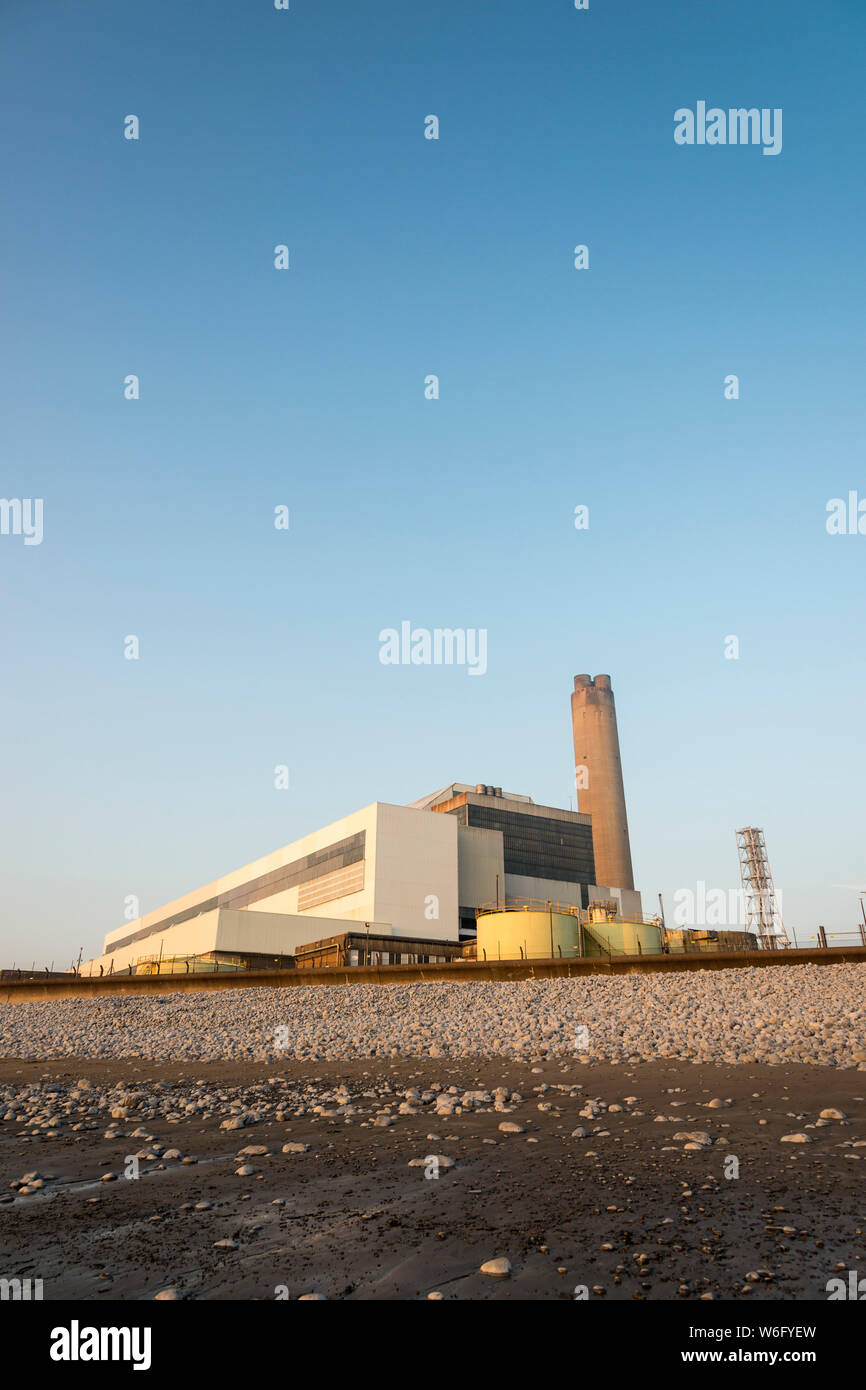 A view of Aberthaw coal fired power station, from the adjacent beach, when it is bathed in pale evening sunlight under a cloudless blue sky. Stock Photo