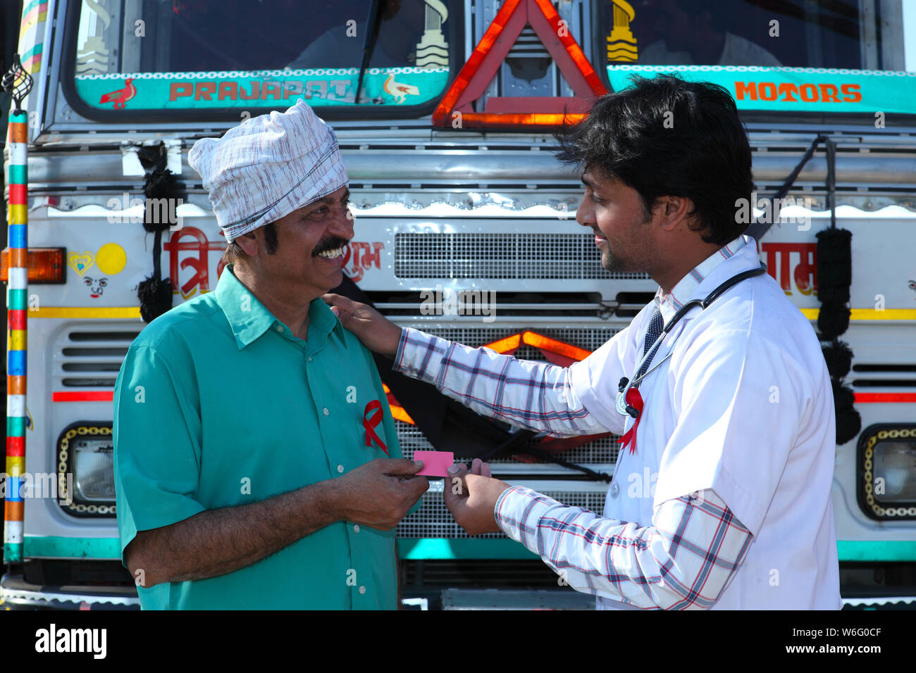 Male doctor giving condom to a truck driver Stock Photo - Alamy