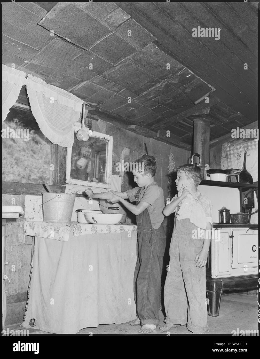 Children washing their hands in the house of Mrs. Leanore Miller, widow of a miner. Kentucky Straight Creek Coal Company, Belva Mine, abandoned after explosion [in] Dec. 1945, Four Mile, Bell County, Kentucky. Stock Photo
