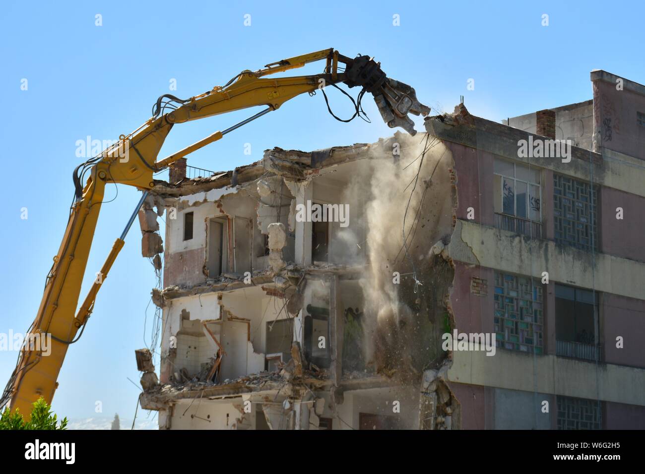 Gran máquina demoliendo un viejo edificio de apartamentos Stock Photo