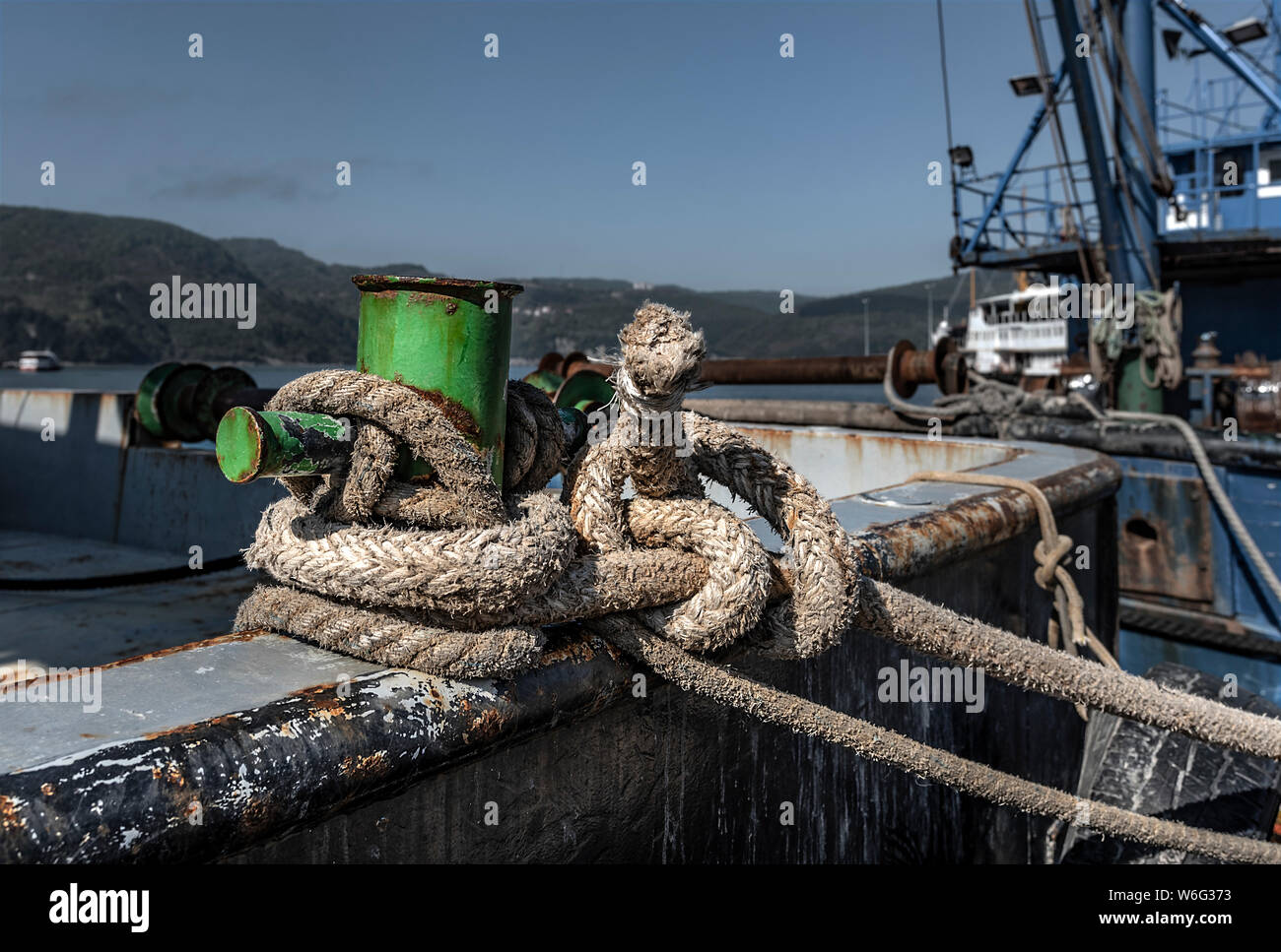 fishing boat tied to pier father with rope Stock Photo - Alamy