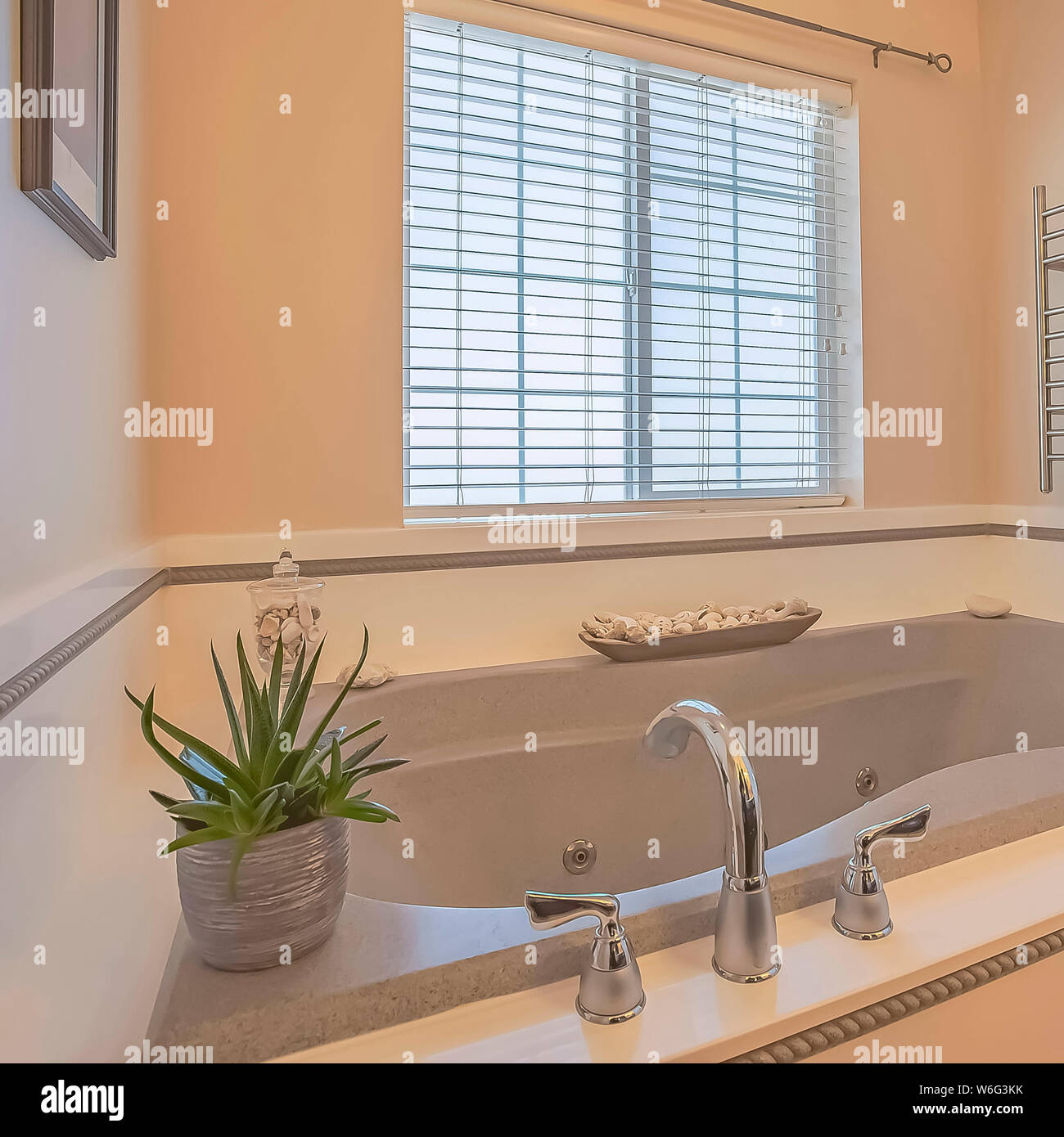 Square Built in bathtub and wall mounted towel rack inside a bathroom