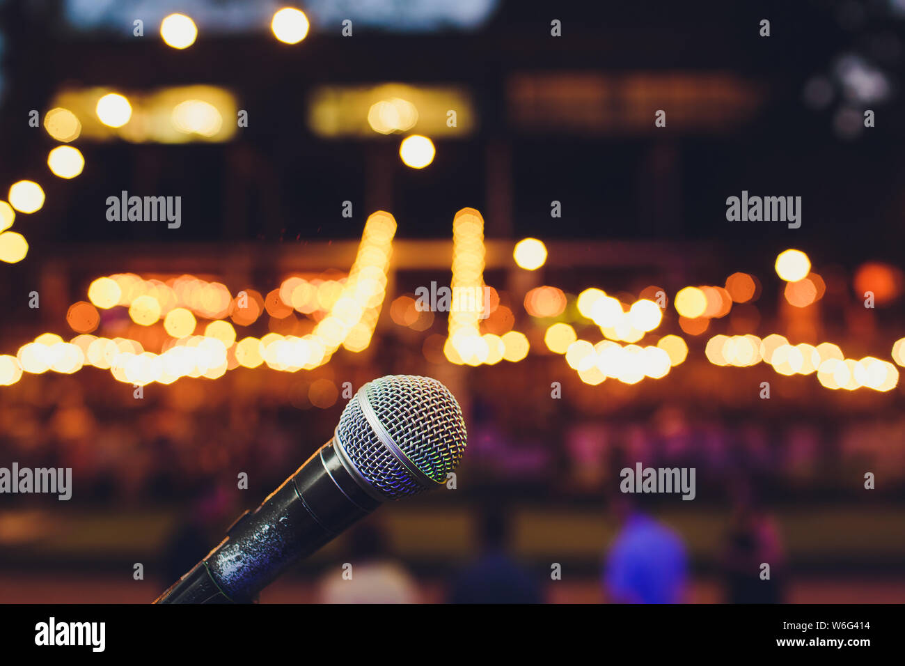 microphone on a stand up comedy stage with colorful bokeh , high contrast image. Stock Photo