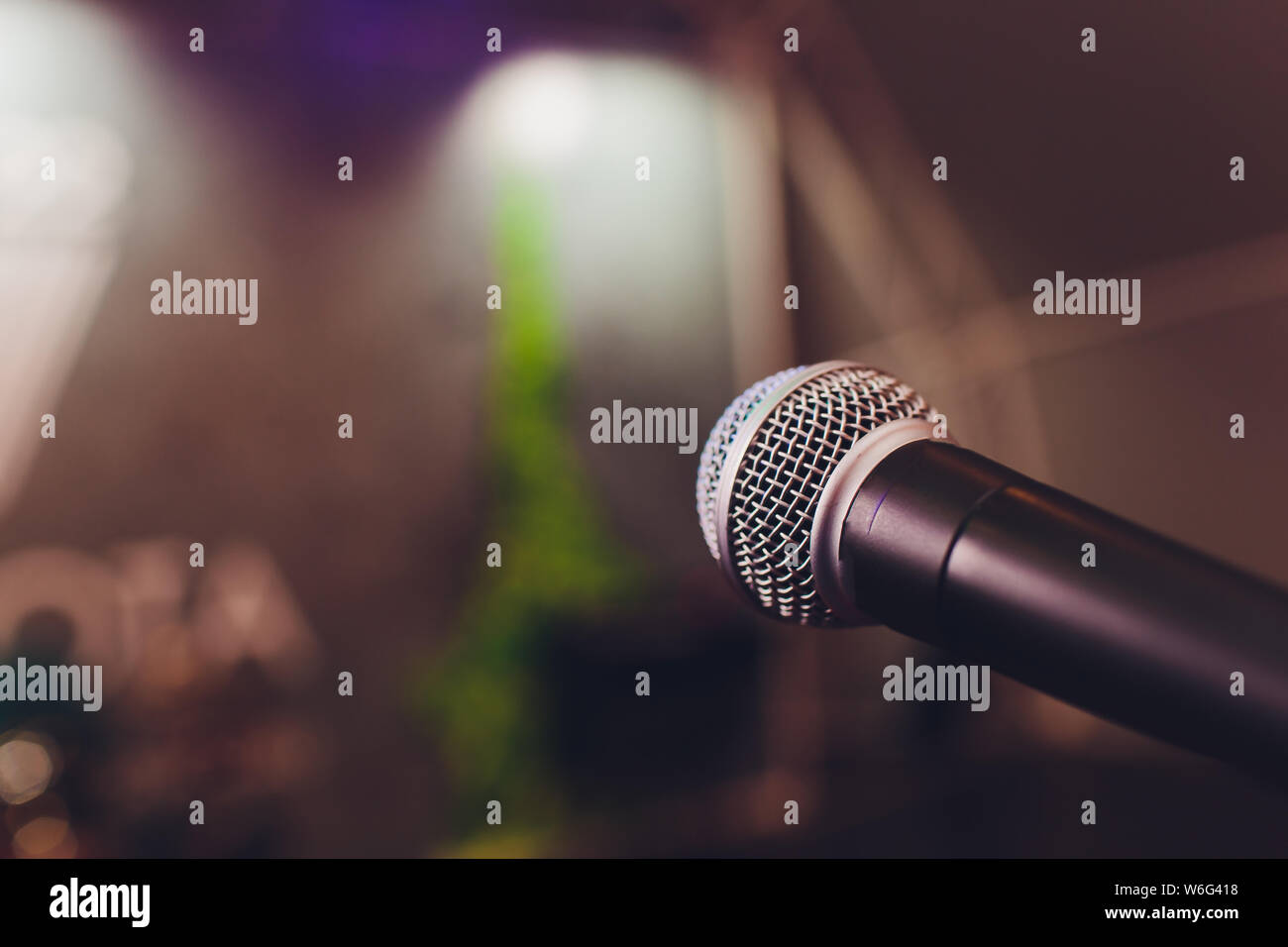 microphone on a stand up comedy stage with colorful bokeh , high