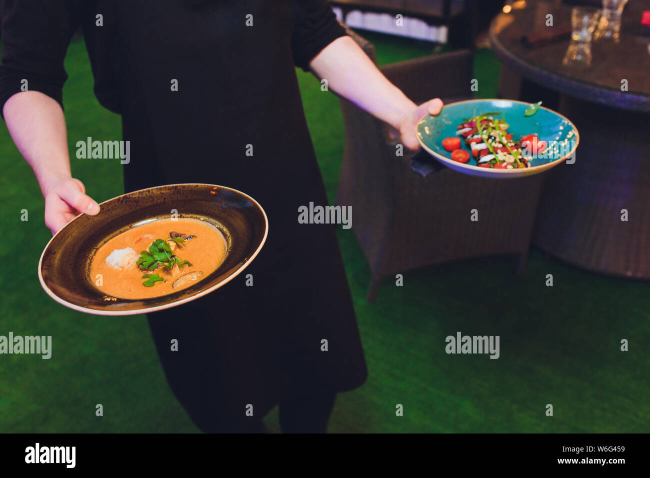 Waitress is carrying two plates with meat dish Stock Photo Alamy