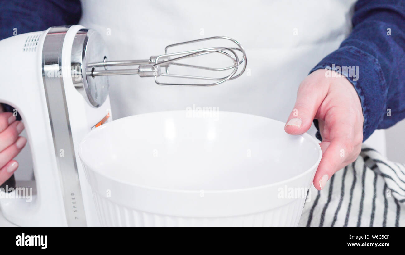 Step by step. Mixing ingredients together in a white mixing bowl to