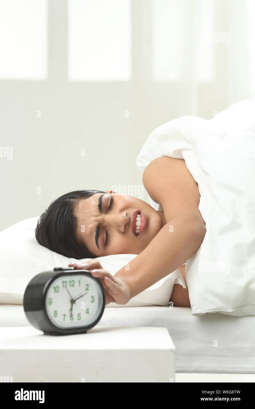 Woman turning alarm off Stock Photo Alamy
