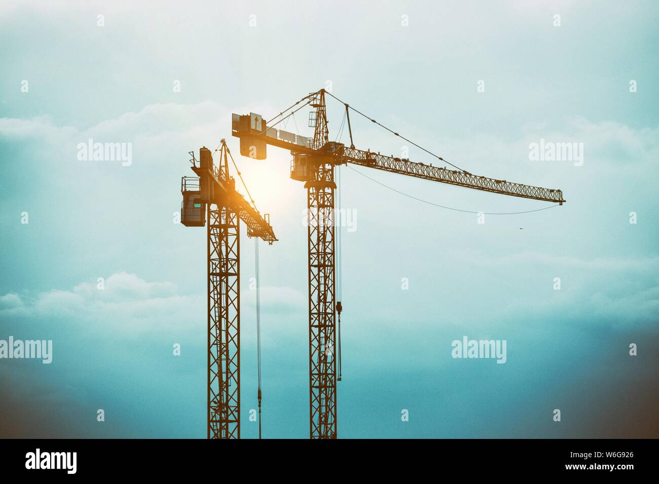 tower cranes against a stormy sky Stock Photo