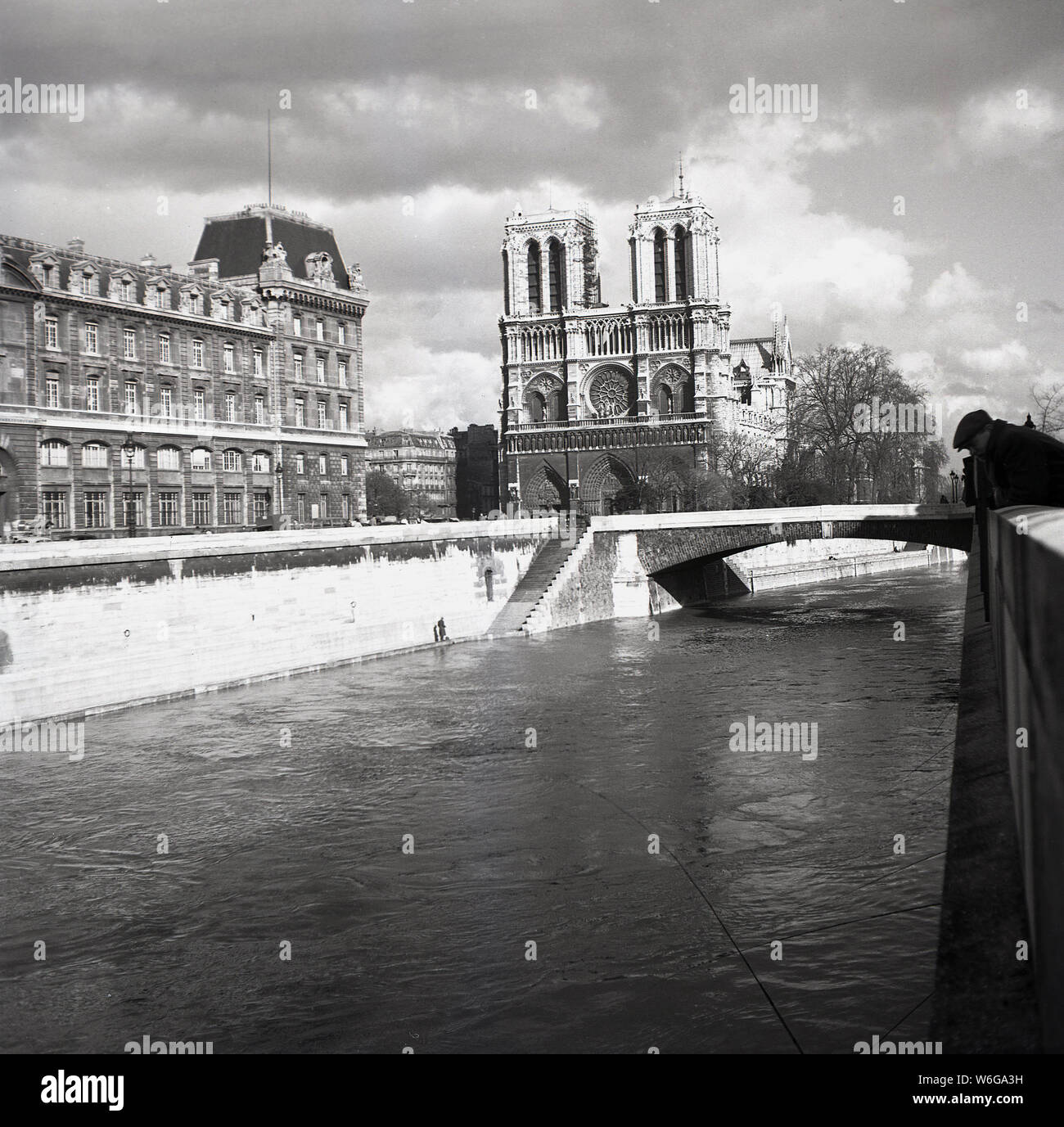 1950s, historical, The Notre-Dame Cathederal as seen from the river Seine, Paris, France. A medieval Catholic church on the IIe de la Cite in the 4th arrondissement of Paris, it is considered one of the finest examples of French Gothic architecture. Stock Photo