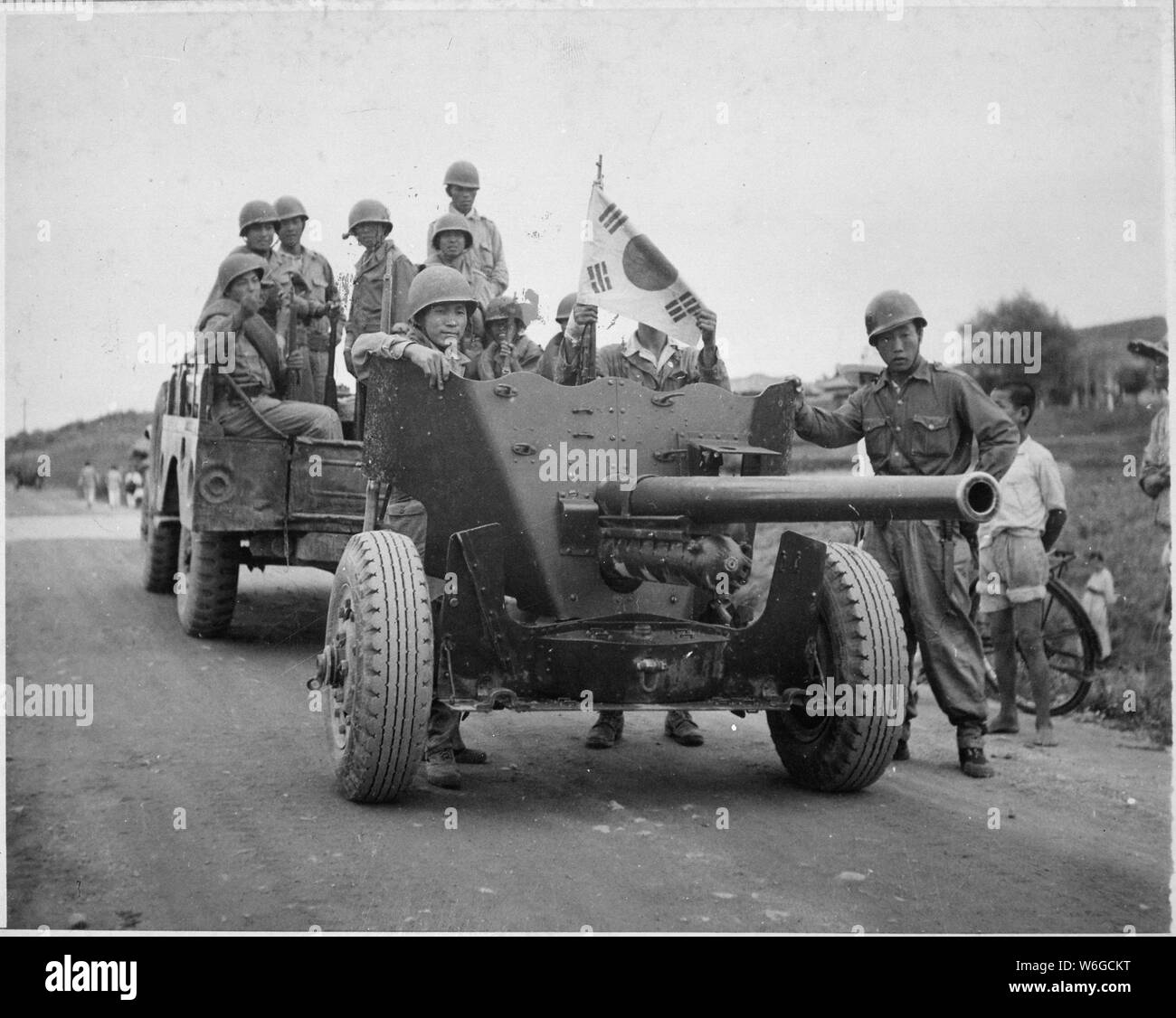 During South Korean evacuation of Suwon Airfield, a 37mm anti-tank gun is hauled out of the area for repairs, by a weapons carrier. International News Photos.; General notes:  Use War and Conflict Number 1387 when ordering a reproduction or requesting information about this image. Stock Photo