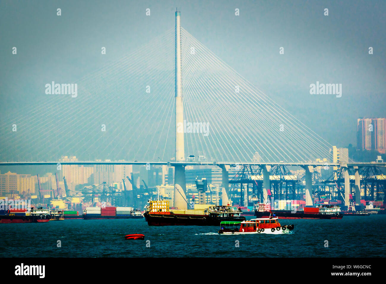 Scenic view of Tsing Ma Bridge in Hong Kong.  Numerous cargo vessels with freight containers. Cityscape of Hong Kong Stock Photo