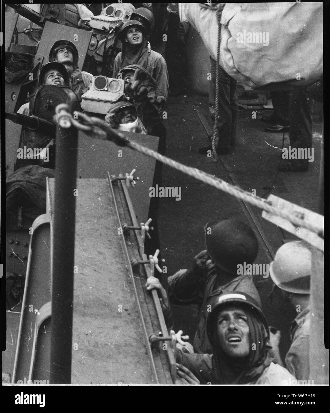 Eyes of 20mm anti-aircraft gun crews of a Navy cruiser covering the Mindoro landing, strain to spot the status of an unidentified plane overhead.; General notes:  Use War and Conflict Number 1204 when ordering a reproduction or requesting information about this image. Stock Photo