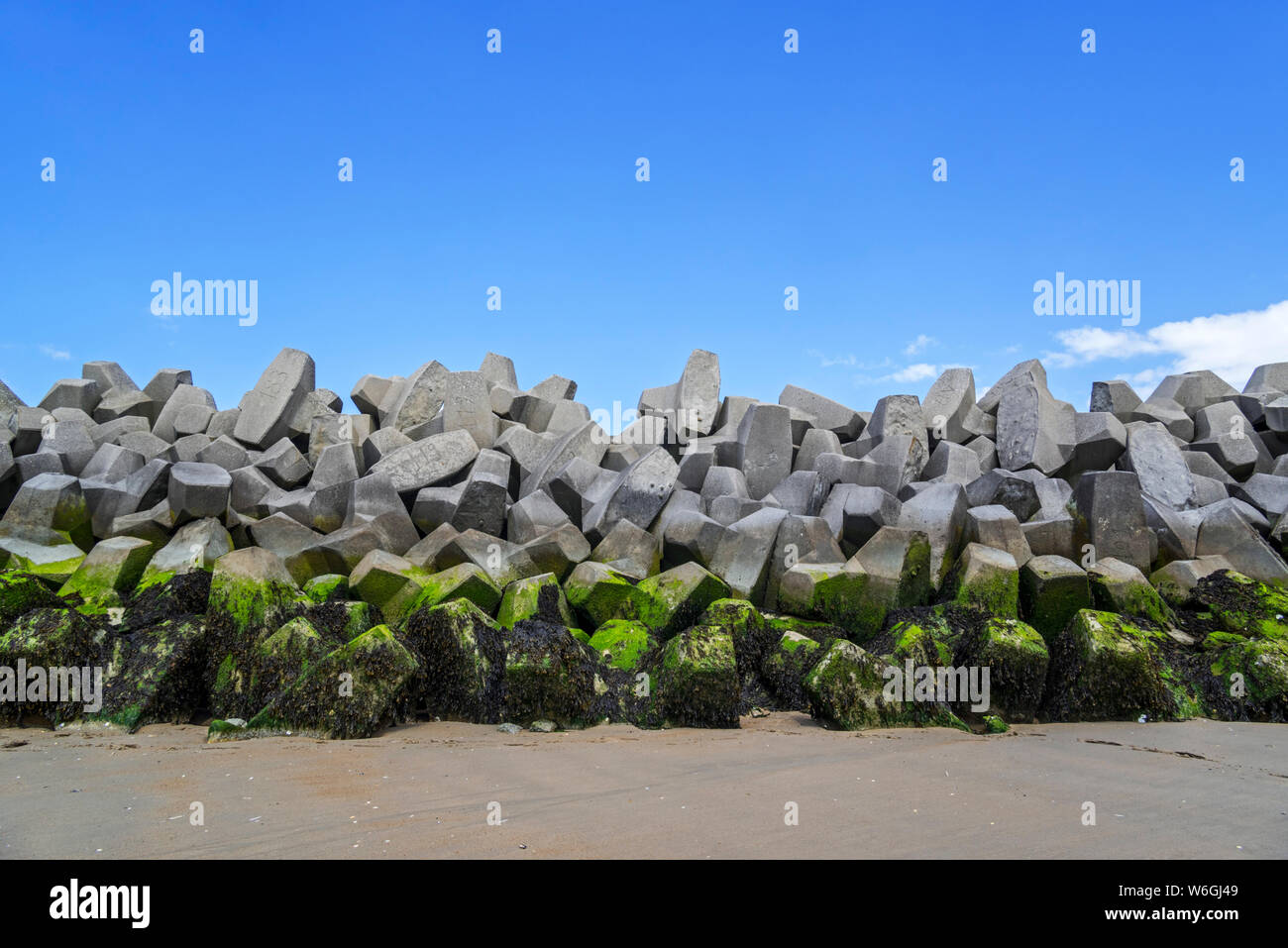 Mound type sea wall / seawall / dam made of concrete blocks, coastal defense at Grand-Fort-Philippe, Pas-de-Calais, Hauts-de-France, France Stock Photo