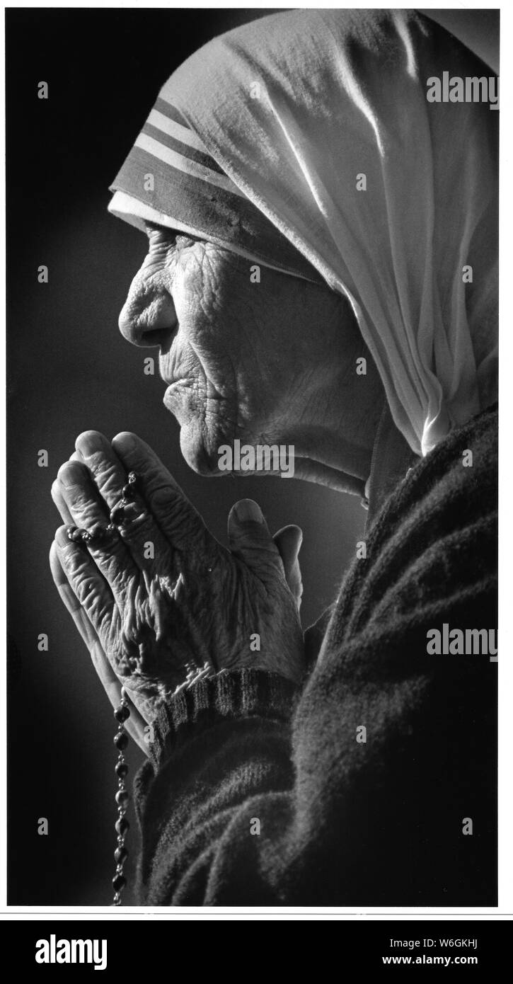 Mother Teresa during her tour of the United States, portrait, face, in the 1980's praying for the sick and hungry people of the world - In Los Angeles California while meeting people in south central LA with the press media - scan from original 8x10 print at 1200dpi.  Mary Teresa Bojaxhiu, commonly known as Mother Teresa and honored in the Roman Catholic Church as Saint Teresa of Calcutta, was an Albanian-Indian Roman Catholic nun and missionary. She was born in Skopje, then part of the Kosovo Vilayet of the Ottoman Empire Stock Photo