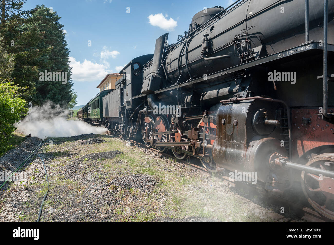 Steam locomotive stops on the tracks, snorting smoke and hot steam Stock Photo