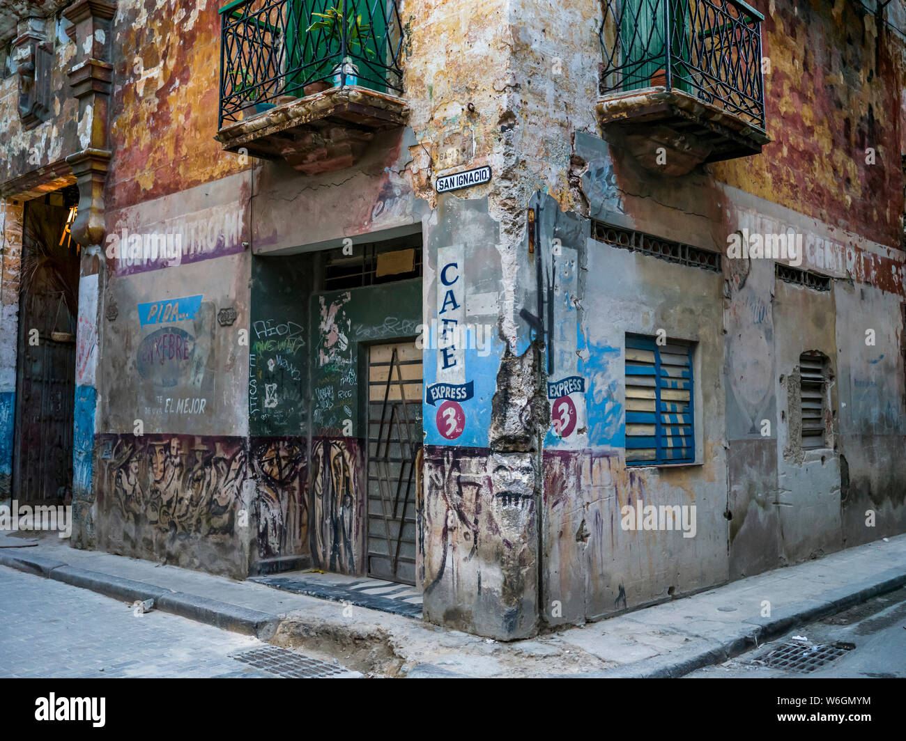 Weathered facade of residential building with advertising on the wall; Havana, Cuba Stock Photo