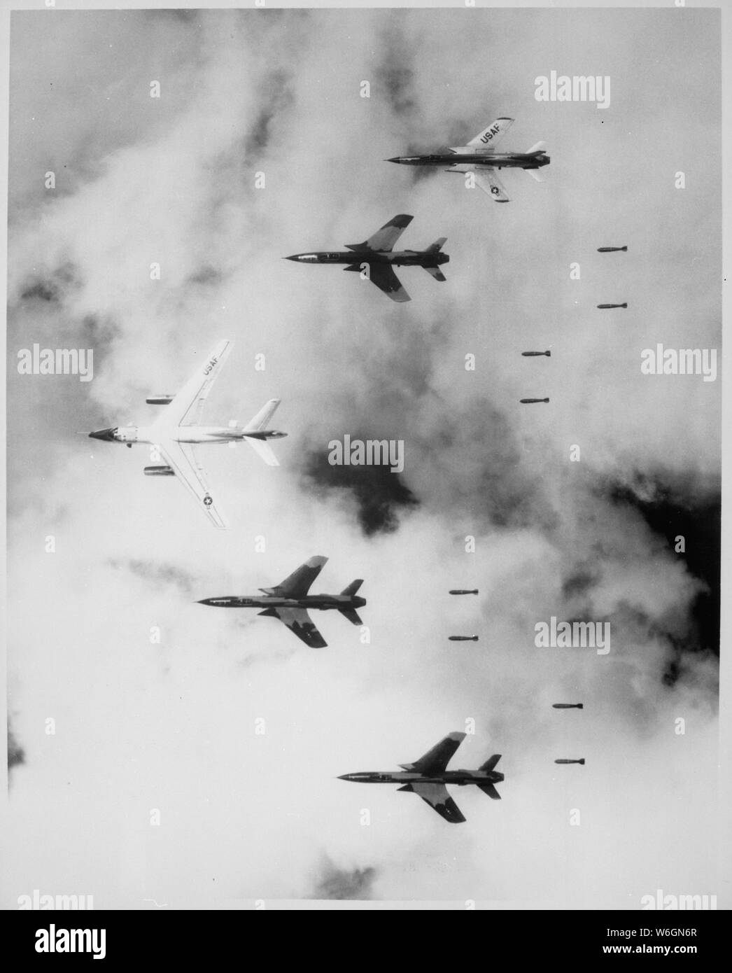 Flying under radar control with a B-66 Destroyer, Air Force F-105 Thunderchief pilots bomb a military target through low clouds over the southern panhandle of North Viet Nam., 07/14/1966; General notes:  Use War and Conflict Number 417 when ordering a reproduction or requesting information about this image. Stock Photo
