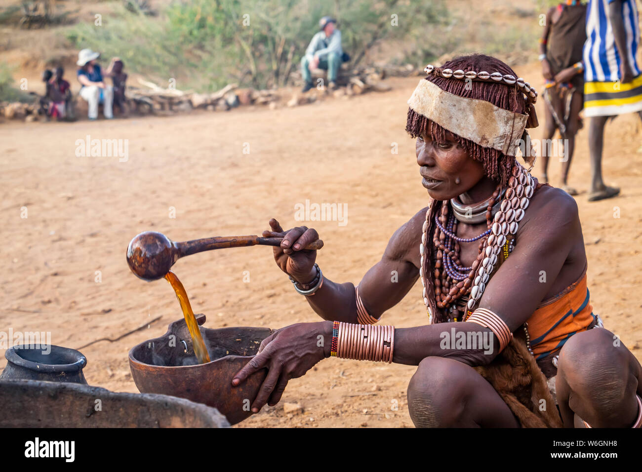 Hamer woman preparing a ceremonial drink at a bull jumping ceremony, which initiates a boy into manhood, in the village of Asile, Omo Valley Stock Photo