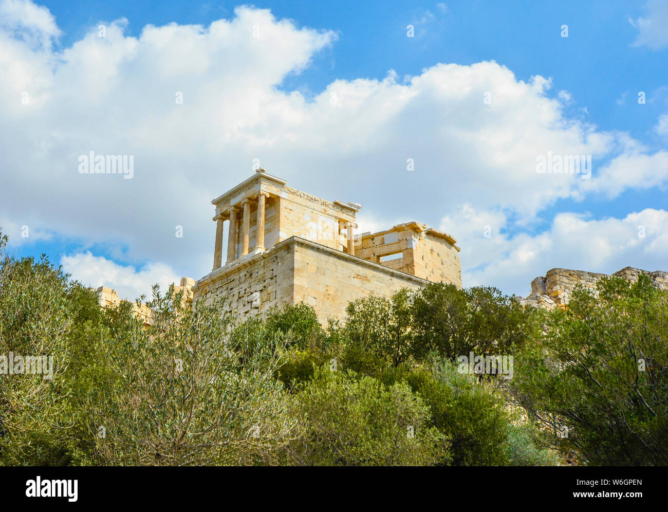A well preserved area of the Parthenon on Acropolis Hill rises above the brush and trees in ancient Athens Greece. Stock Photo