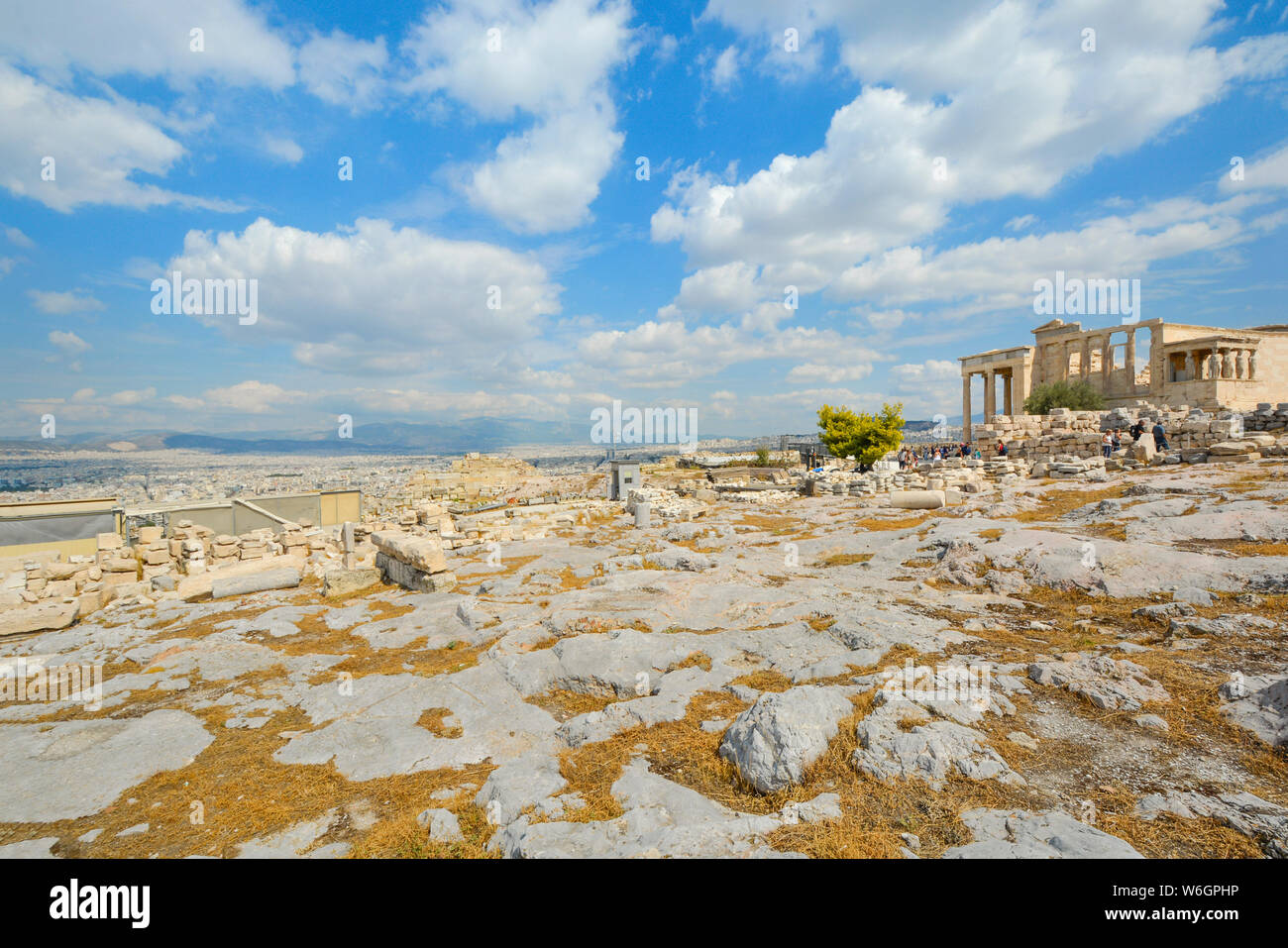 A warm summer day in Athens Greece as tourists enjoy the city view and explore the ancient Erechtheion on Acropolis Hill, a world heritage site Stock Photo
