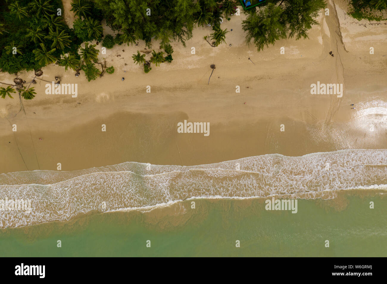 Aerial view of waves breaking on an empty, sandy tropical beach Stock Photo