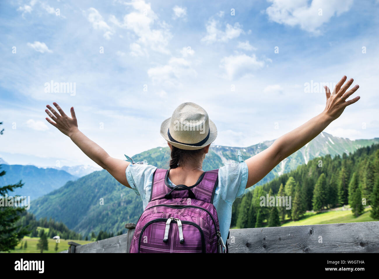 Woman With Backpack Enjoying Panoramic Mountain View Stock Photo