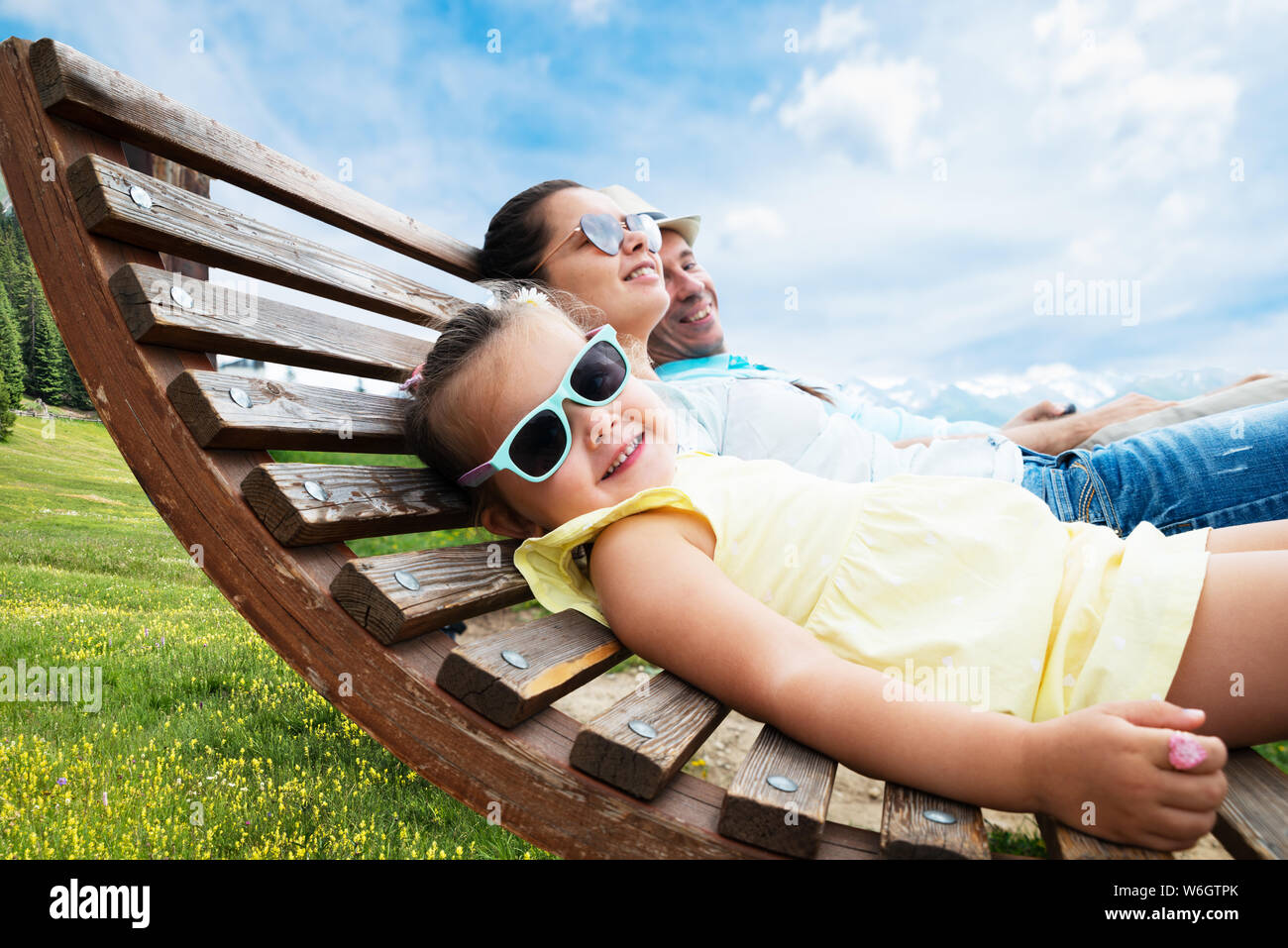 Family With Little Relaxing In Sun Lounger In Mountains Stock Photo
