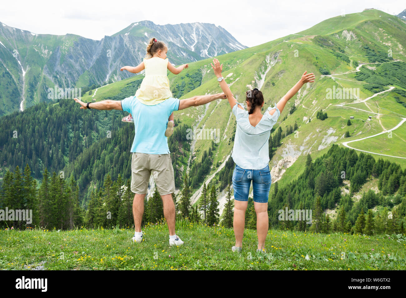 Rear View Of Happy Family Looking At Panoramic Mountain View Stock Photo