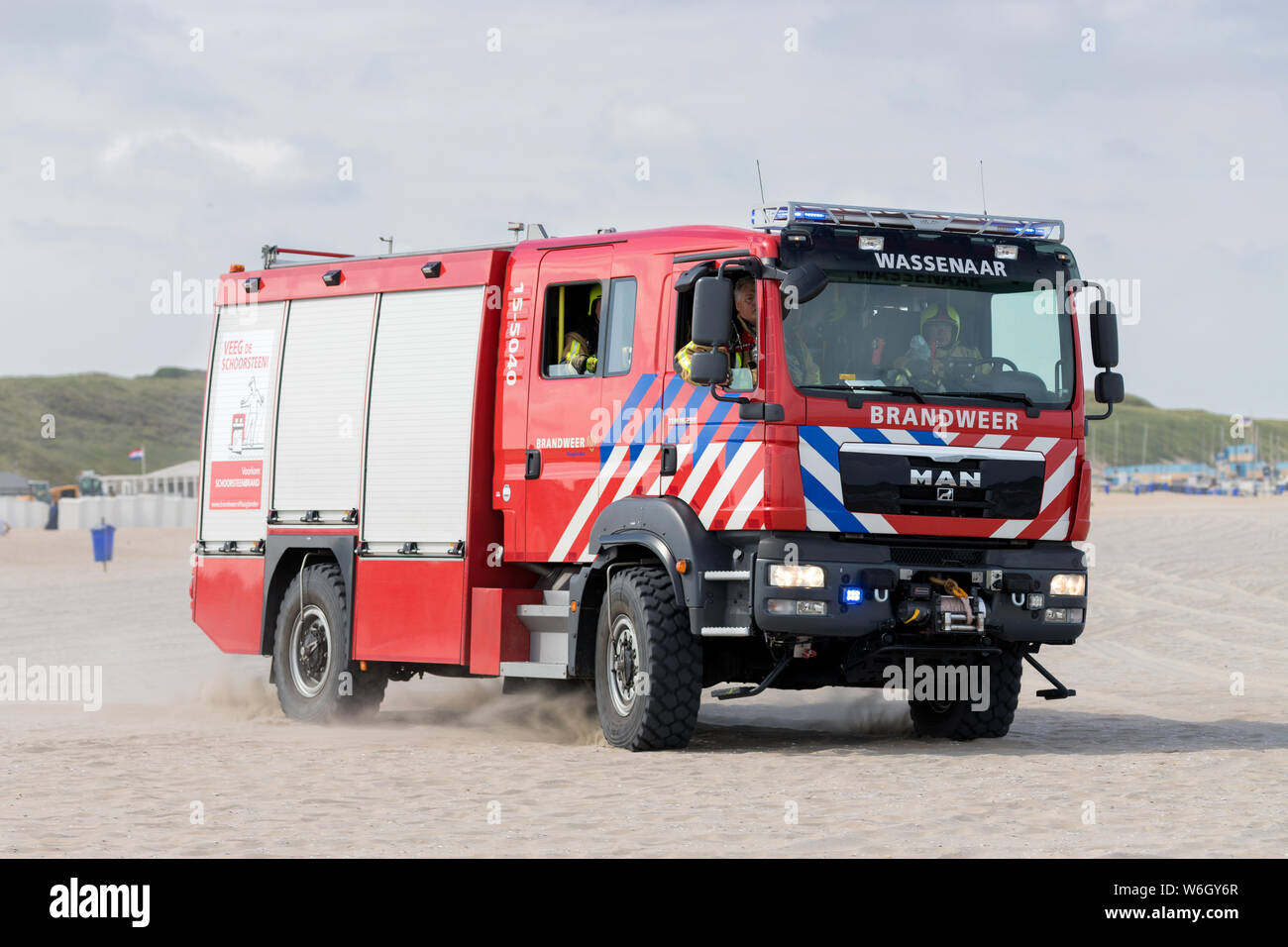 Dutch MAN TGM fire engine with active blue emergency lighting on the beach Stock Photo