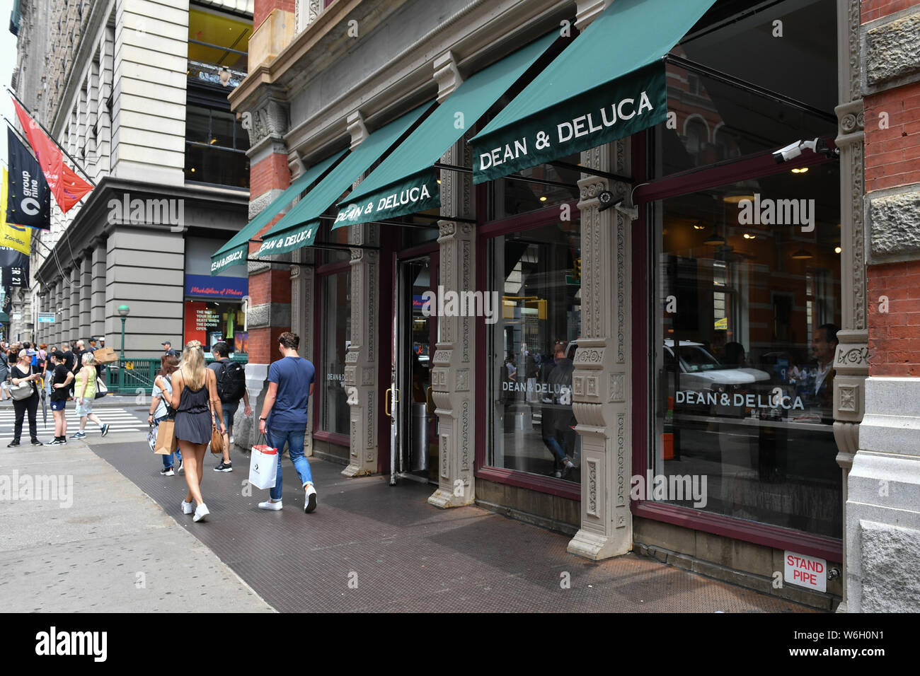 Pedestrians pass in front of a Dean & DeLuca store in the Soho neighborhood of New York. Stock Photo