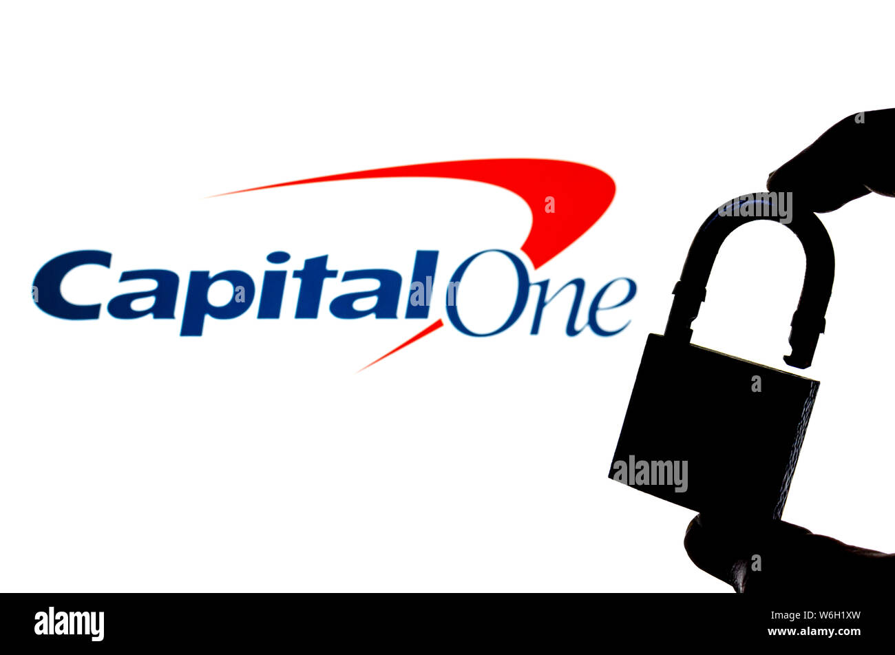 Capital One Bank logo on the background screen and a silhouette of the opened lock in front. Conceptual photo for news about the data breach. Stock Photo