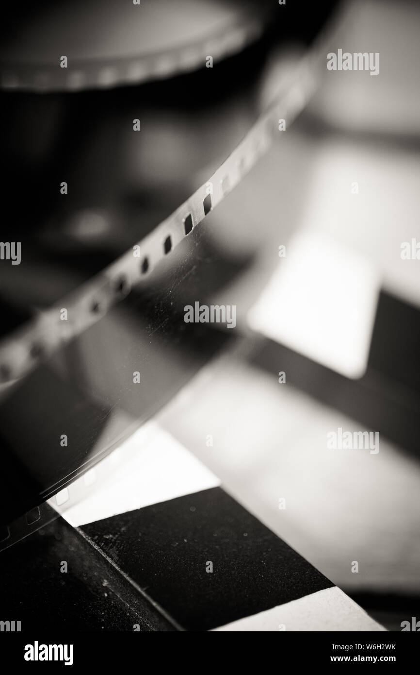 Extreme close up of filmstrip on  movie slate selective focus on foreground black and white vintage old fashioned Stock Photo