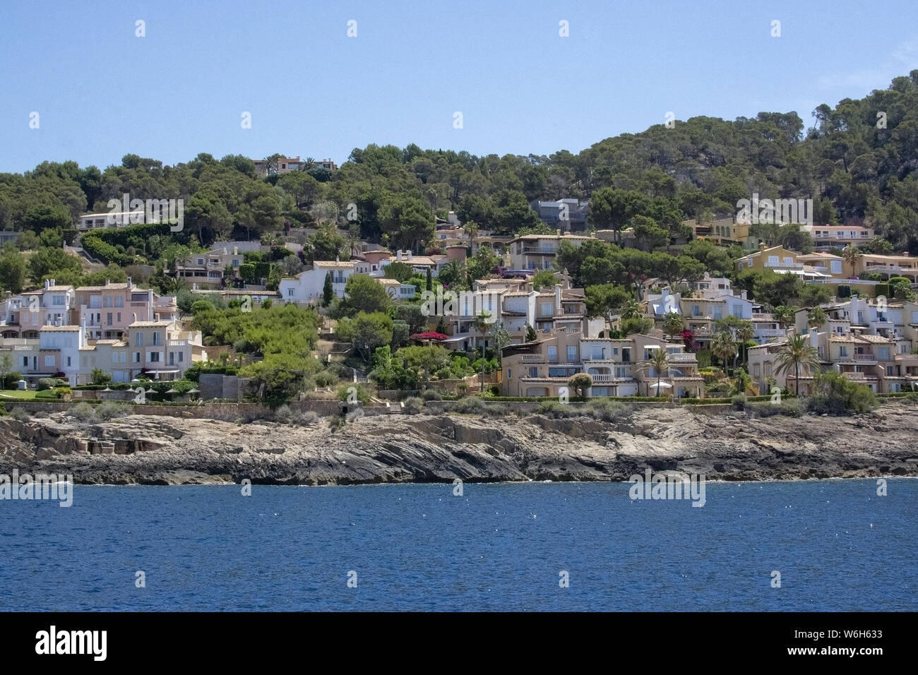 Sunny seaside small homes on a coast in southwest Mallorca, Spain. Stock Photo