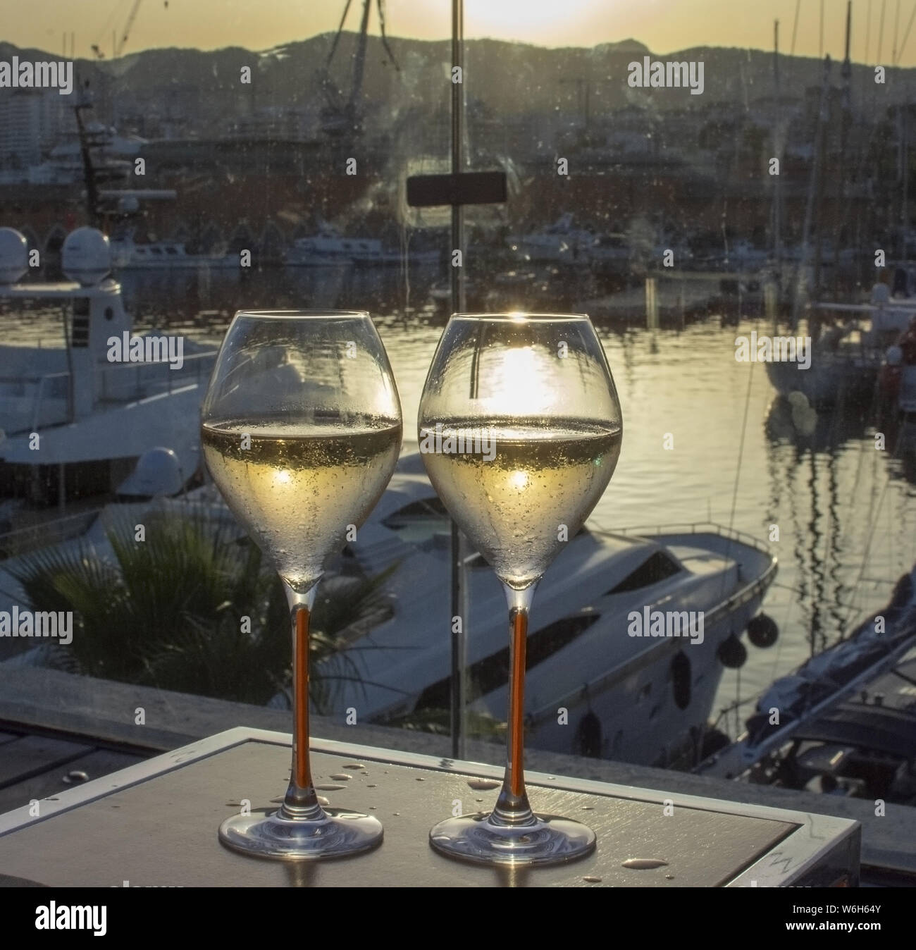 Two champagne flute glasses at sunset by the water in sunshine romantic Mallorca, Spain. Stock Photo