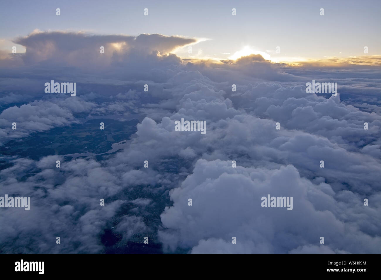 Dreamy aerial cloud landscape flying high above the Earth with thunderclouds on a sunny day. Stock Photo