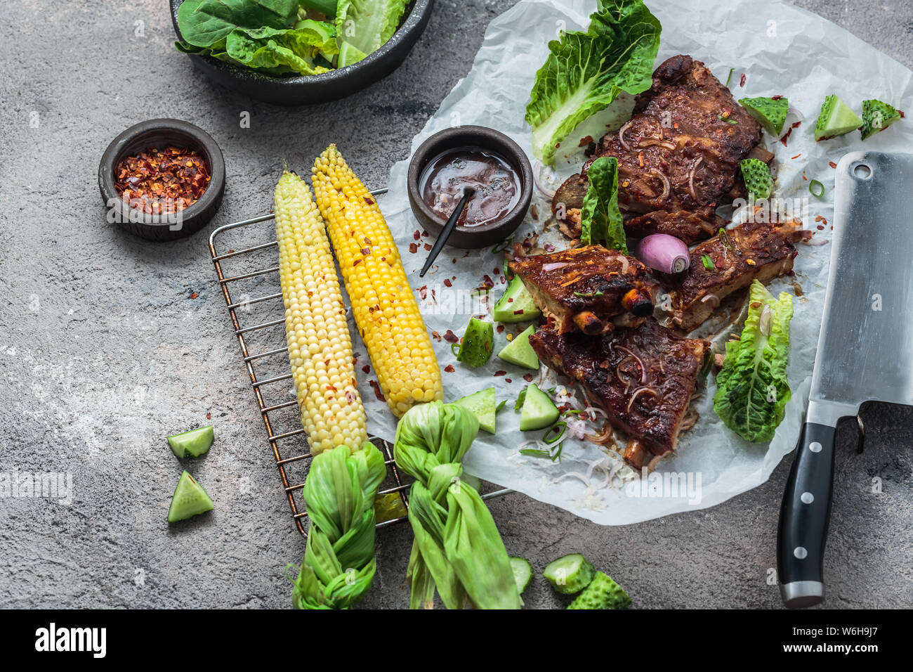 Pork ribs and corn on concrete background, copy space Stock Photo