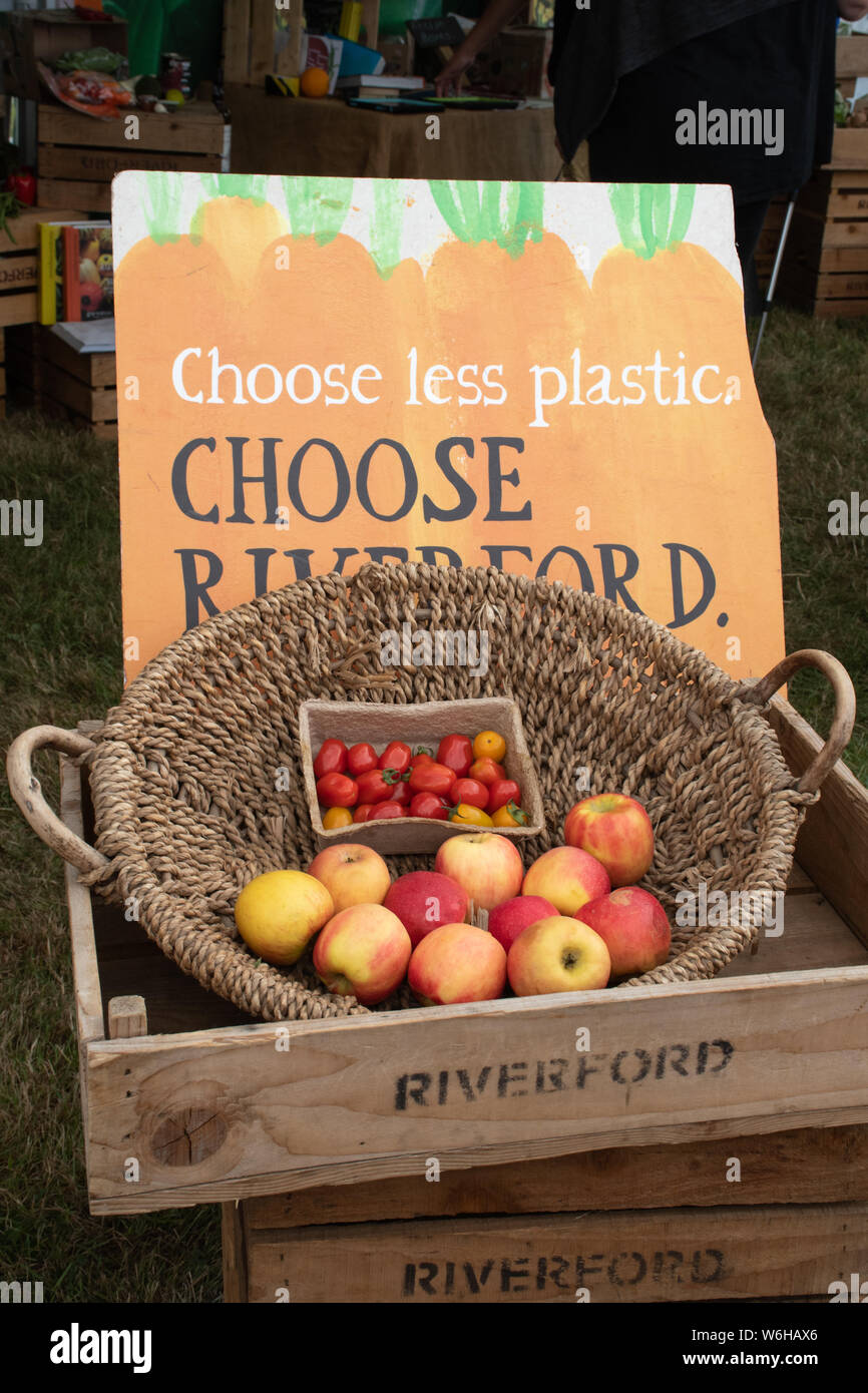 Basket with fruit and vegetables and a sign reading Choose less plastic, Choose Riverford, UK Stock Photo