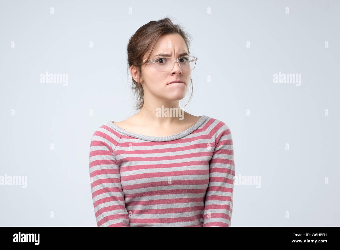 Woman in glasses looks aside with pensive expression, Stock Photo