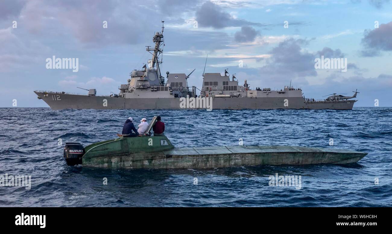 The U.S Navy Arleigh Burke-class guided-missile destroyer USS Michael Murphy intercepts a low profile vessel with suspected smugglers in the Pacific Ocean July 25, 2019 off the coast of California. Stock Photo