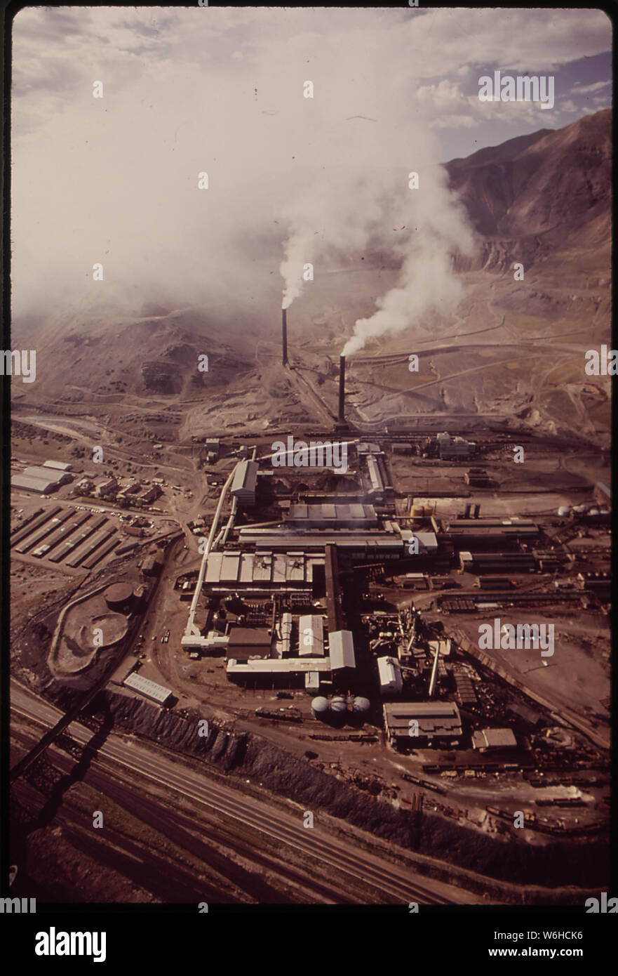 HEAVY SMOKE POURS FROM THE TWIN STACKS OF THE KENNECOTT SMELTER. THE