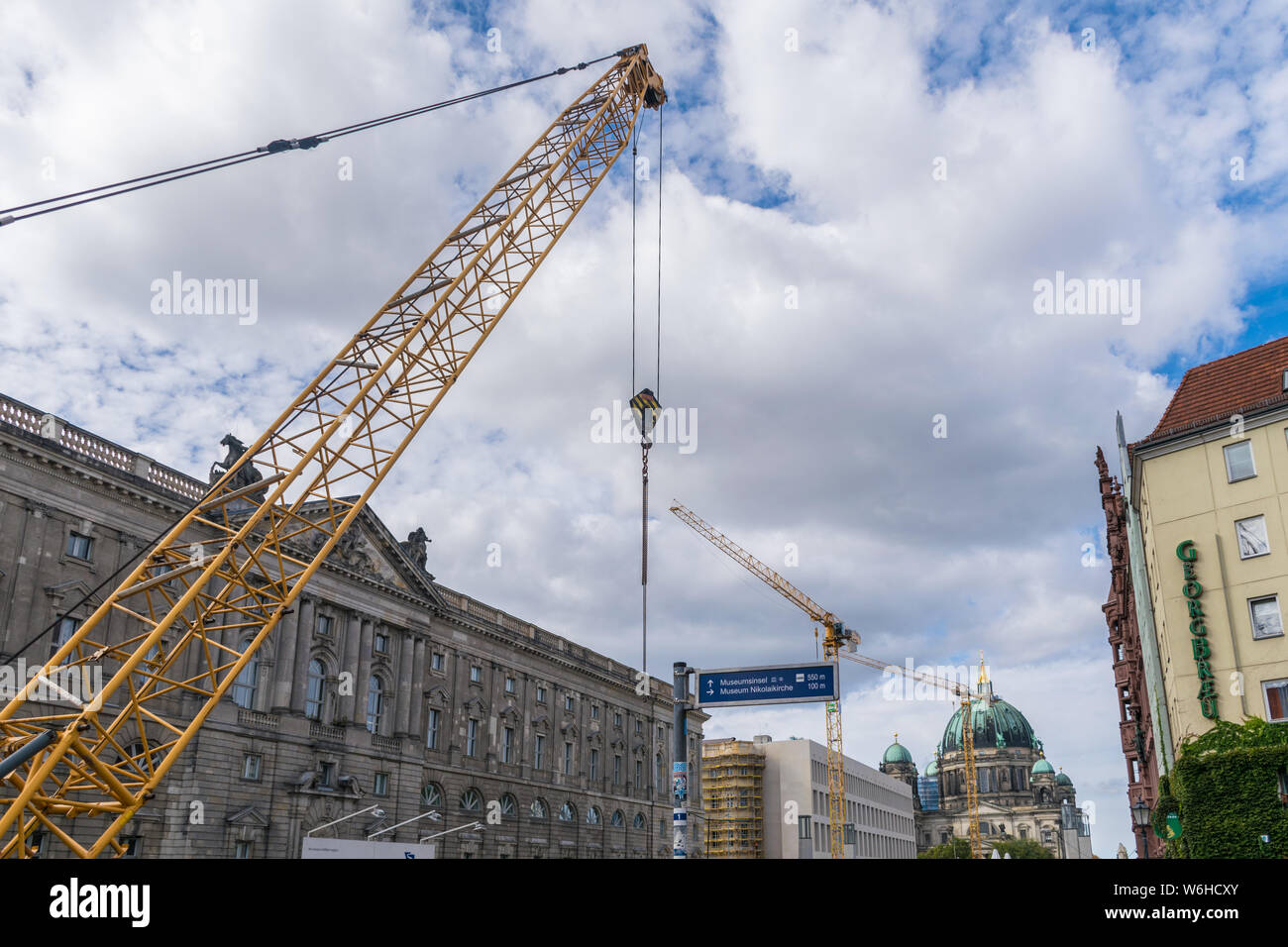 BERLIN, GERMANY - September 26, 2018: Yellow tower cranes working in reforms with the Berliner Dom, the Berlin Cathedral, a great history construction Stock Photo