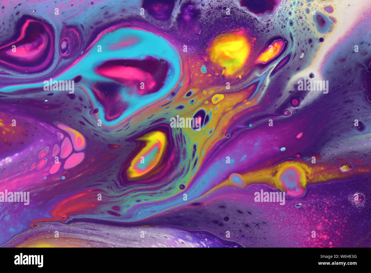 Vivid neon colors create a cosmic feel to these acrylic pour paintings perfect for colorful backgrounds. Stock Photo