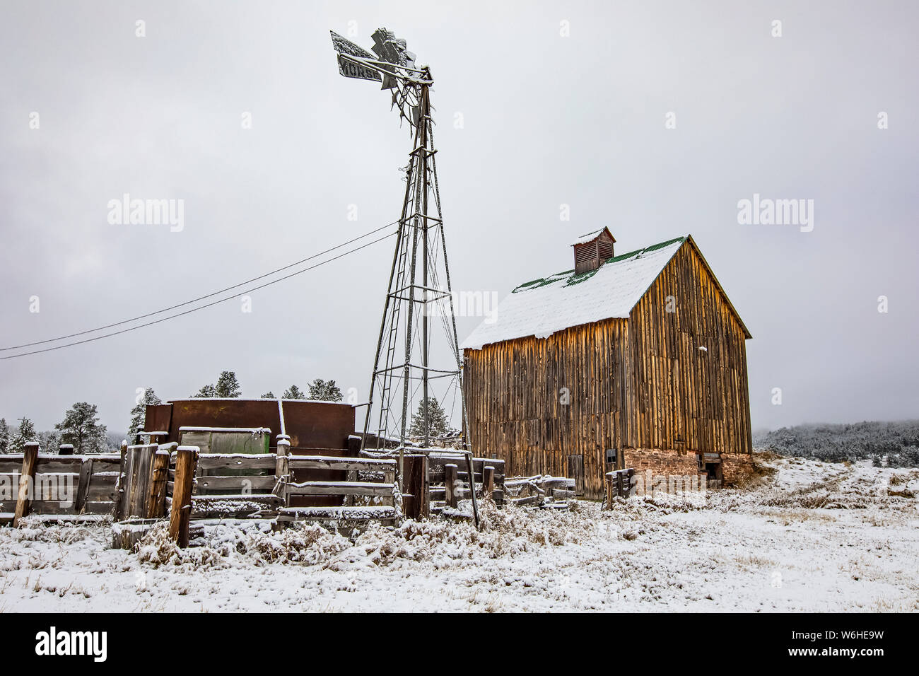 Farmyard with barn and windmill covered in snow; Denver, Colorado, United States of America Stock Photo